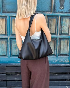 Mała czarna torebka na ramię LUNA w miękkim fasonie slouchy hobo, prezentowana na modelce.